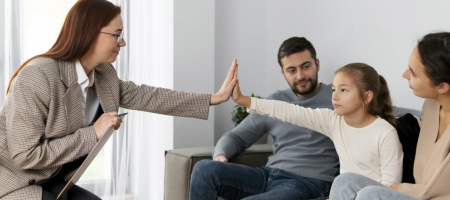 therapist high-fiving an autistic child