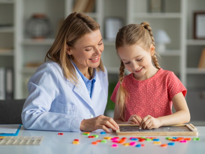 child playing learning game with therapist