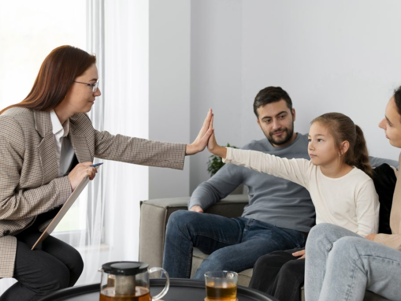therapist high-fiving an autistic child