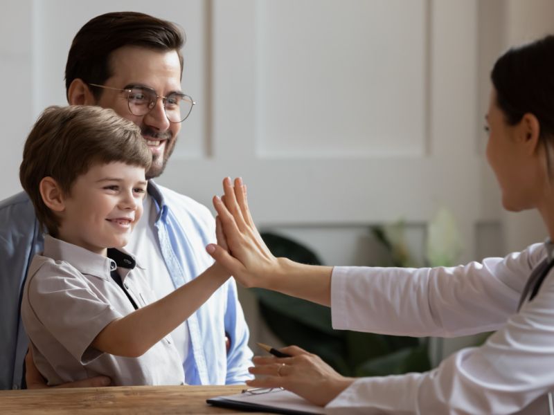 child high-fiving with therapist